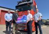 Four men standing in front of a Manfreight lorry holding a photo prop to promote the Junior Sports Awards 2025.