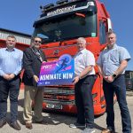 Four men standing in front of a Manfreight lorry holding a photo prop to promote the Junior Sports Awards 2025.