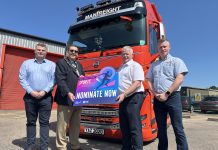 Four men standing in front of a Manfreight lorry holding a photo prop to promote the Junior Sports Awards 2025.