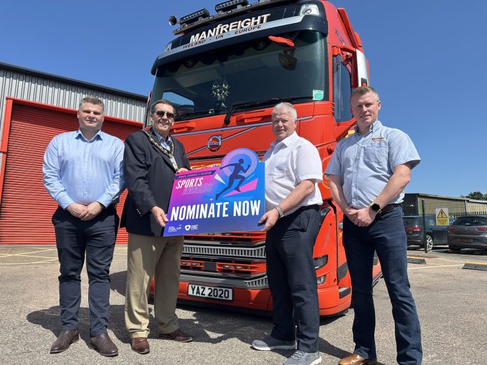 20250611_142456691_iOS Four men standing in front of a Manfreight lorry holding a photo prop to promote the Junior Sports Awards 2025.