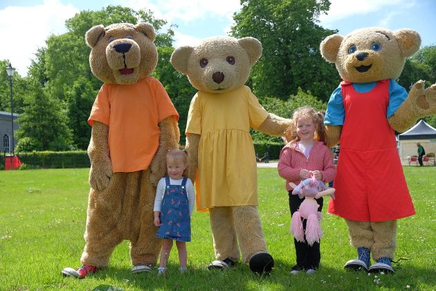 Children beside teddy bear mascots