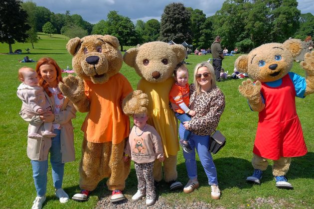 Family and children beside teddy bear mascots