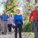 A small group of adults walking through the countryside.