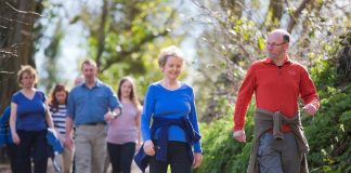 A small group of adults walking through the countryside.