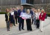 12 people standing with 2 people holding a board saying Ultimate Pitch.