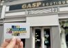 A hand holding a Shop ABC Gift Card outside Gasp Boutique