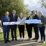 ABC Council launches €7.7m PEACEPLUS programme Six people stand in a row holding two signs reading PEACEPLUS and 7.7 Euro million.