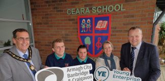 A group of people standing outside Ceara School holding ABC Council logo and Young Enterprise NI logo.