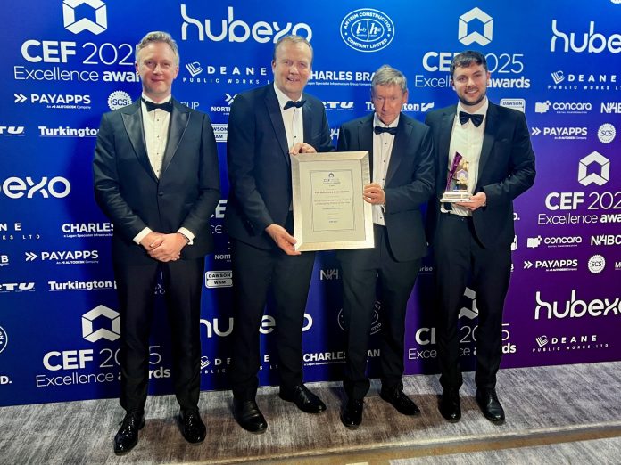 Four men standing at an awards ceremony with a framed certificate, with one man holding a crystal award.