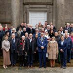 A group of people standing on the steps of an historic building