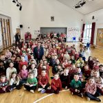 Lord Mayor sitting among the pupils and staff of St Teresa's Primary School, Lurgan