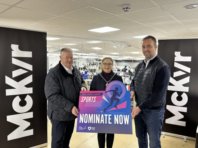 Three people are standing in a row holding a sign to promote the senior sports awards - nominations open.