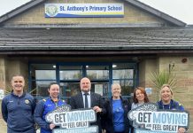 Six staff from St Anthony's Primary School standing outside the school holding signs to promote the council's Get Moving programme.
