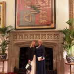 Two women standing beside fireplace