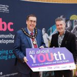 Conference empowers professionals working with children and young people Two men holding a sign saying All About YOUth conference