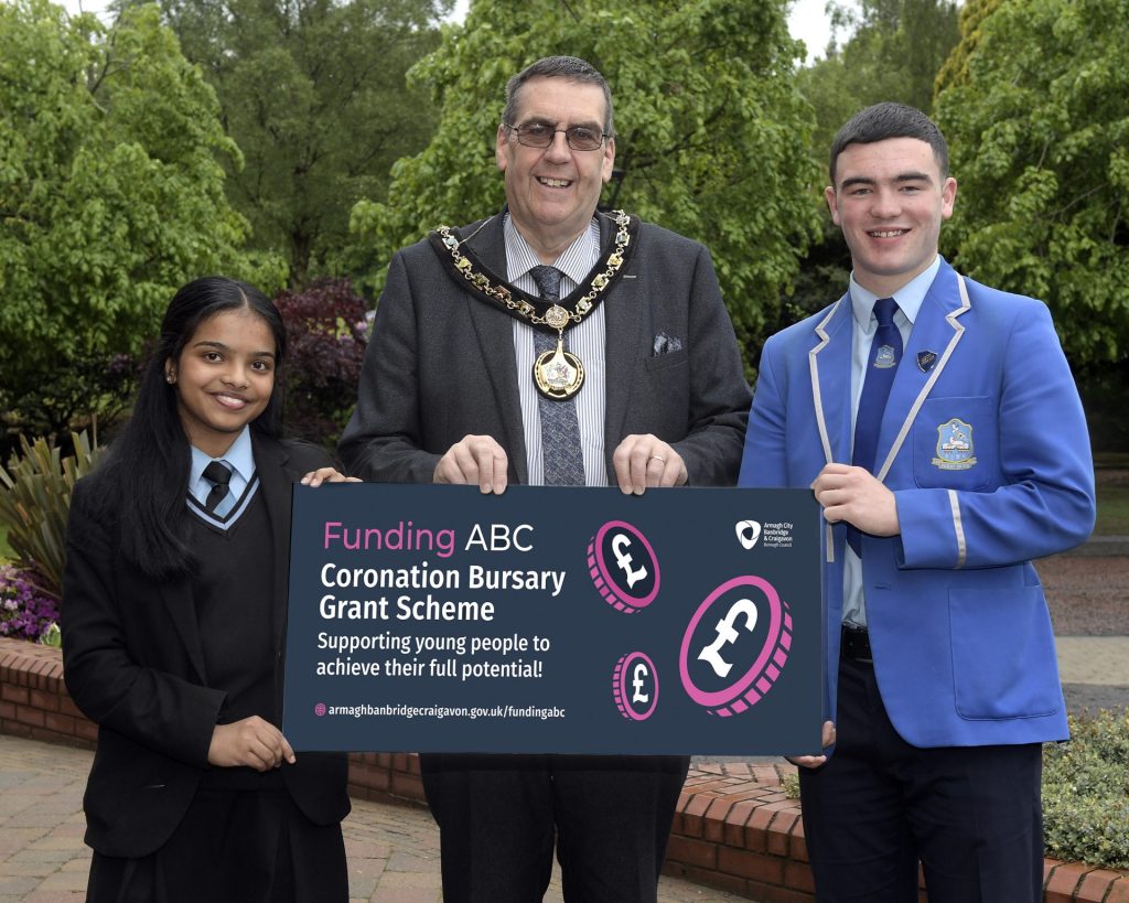 Lord Mayor pictured standing between a male student and a female student.
