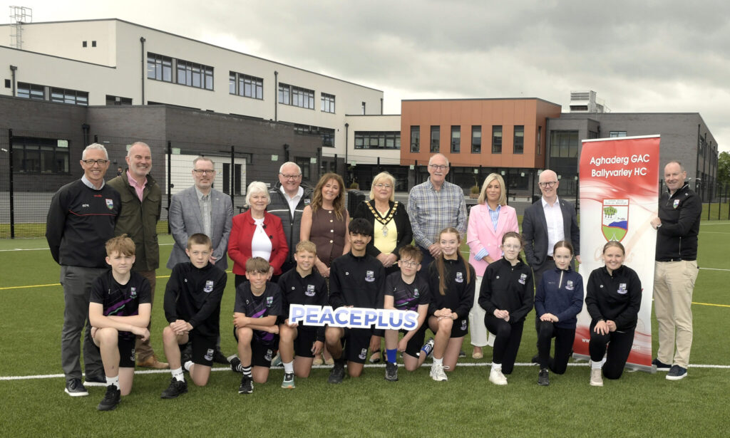 A large group of people standing on a school pitch.
