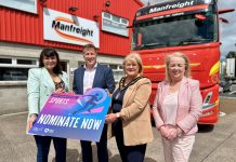 4 people standing in front of a Manfreight Ltd lorry holding a banner promoting the junior sports awards.