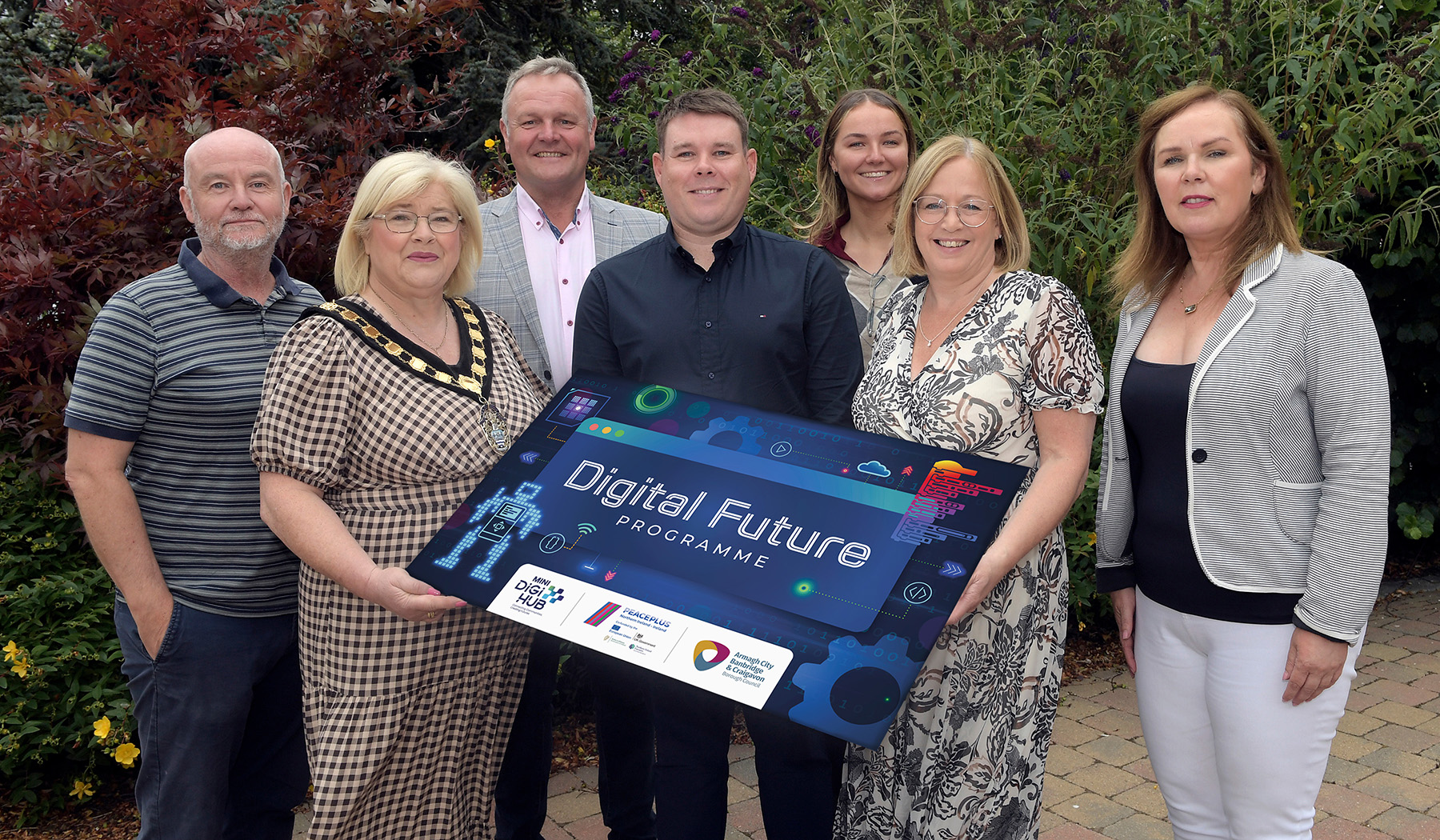 A group of people including a female wearing a mayoral chain holding a sign for the Digital Future programme.