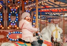 Young girl sitting on a merry go round horse