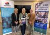 Three people standing in front of positive ageing month banners