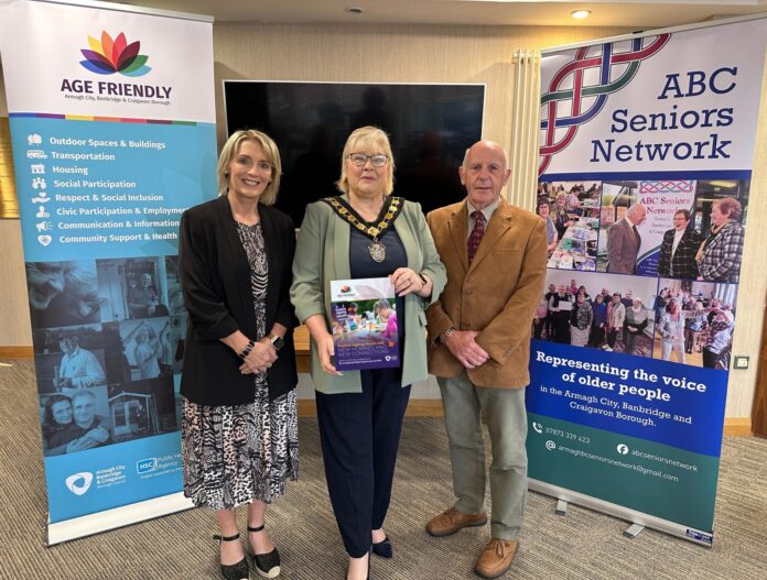 Three people standing in front of positive ageing month banners