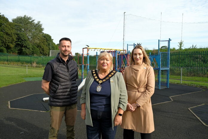 3 people standing in front of play equipment in a playpark.
