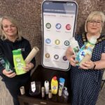 Two females holding household waste items which can be recycled