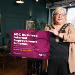Lord Mayor standing in a shop holding a board that says ABC Business Internal Improvement Scheme