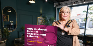 Lord Mayor standing in a shop holding a board that says ABC Business Internal Improvement Scheme