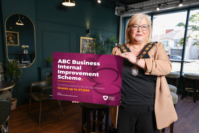 Lord Mayor standing in a shop holding a board that says ABC Business Internal Improvement Scheme
