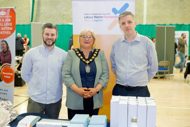 People standing together at a job fair, looking at the camera