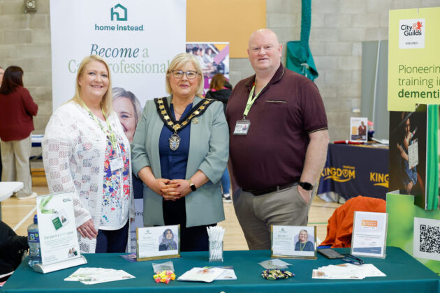 People standing together at a job fair, looking at the camera