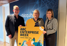 Three people holding a sign that says ABC Enterprise Week