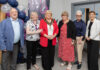 Celebrating a decade of funding for community and voluntary groups! 6 people stand together at the funding celebration event.