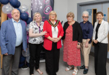 Celebrating a decade of funding for community and voluntary groups! 6 people stand together at the funding celebration event.